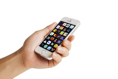Birçok farklı uygulama simgesine sahip kişi cep telefonunu tutuyor 