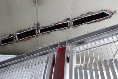 Açığa çıkan tavan kirişleri binanın içindeki metal güvenlik kapısının üstünde.