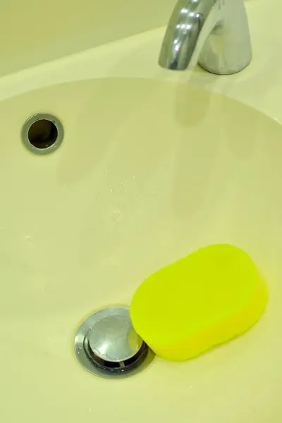 シンクのクローズアップビューの黄色いスポンジ — ストック写真