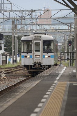 Modern banliyö treni boş demiryolu platformuna yaklaşıyor.