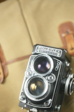 Kahverengi deri çantanın önünde eski çift lensli kamera Rolleiflex