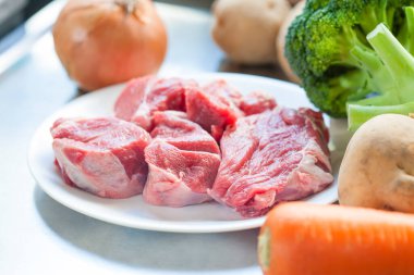 Taze çiğ et parçaları ve sebzeler pişirmeye hazır. 