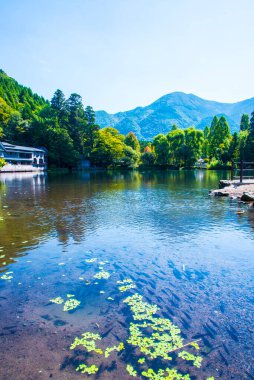 Yufuin, Oita, Kyushu, Japonya 'daki Yufu Dağı ve mavi gökyüzü geçmişi ile Kinrin Gölü.