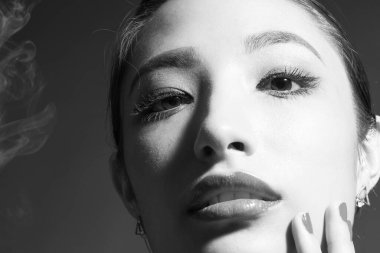 Sigara içen beyaz elbiseli güzel Asyalı kadın.