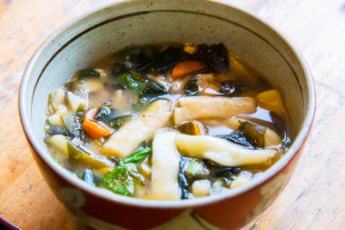 Sebzeli Japon çorbası ve ahşap masada mantar.