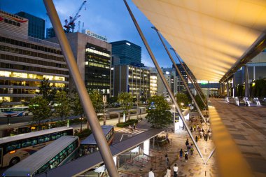 Chuo Ward, Tokyo 'da. Alacakaranlıkta Tokyo İstasyonu 'nun Yaesu çıkışındaki insanlar. İstasyonla bütünleşen binaların adı Gran Tokyo