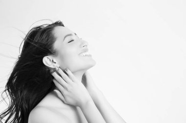 Beyaz arka planda uzun saçlı ve makyajlı genç Asyalı kadın.