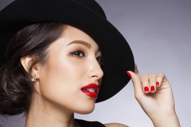 Stüdyoda şık makyajlı güzel Asyalı bir kadının yakın plan fotoğrafı.