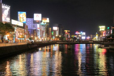 Köprü ve Aydınlatılmış Billboardları olan Japon Şehir Nehrinin Gece Görüşü