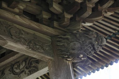 Geleneksel Japon tapınağının çatısını destekleyen entrika oyulmuş ahşap kiriş