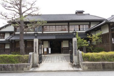 Geleneksel Japon binası yeşillik ve yollarla çevrili.