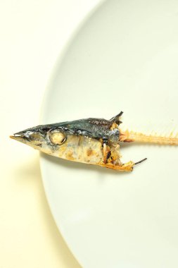 balık başı ve kemikleri tabağın üstünde 