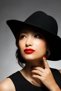 Siyah şapkalı ve kırmızı rujlu Asyalı kadın.