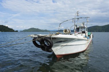 Dağın arka planında bir balıkçı teknesi.