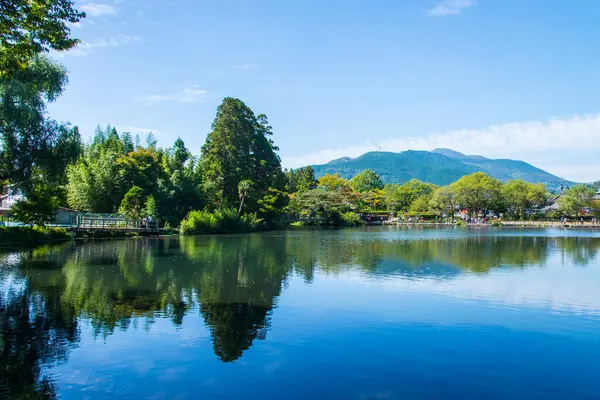 Yufuin, Oita, Kyushu, Japonya 'daki Yufu Dağı ve mavi gökyüzü geçmişi ile Kinrin Gölü.