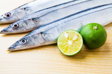 Tahta zemin üzerinde limon dilimi olan taze balık..