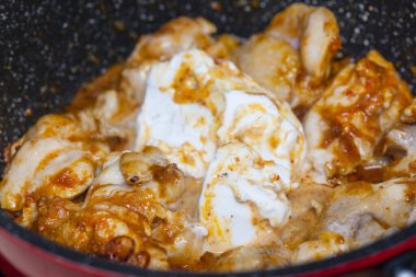 Soslu tavuk eti ve tavada baharat.