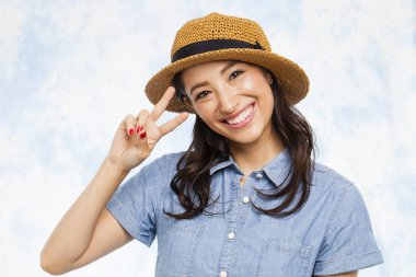 Gülümseyen kadın barış hareketi ve barış işareti gösteriyor.