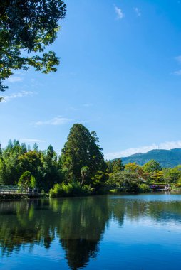 Yufuin, Oita, Kyushu, Japonya 'daki Yufu Dağı ve mavi gökyüzü geçmişi ile Kinrin Gölü.