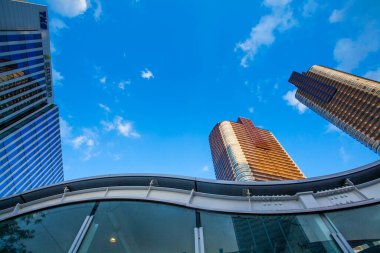 Modern şehirdeki gökdelenlerin alçak açılı görüntüsü mavi gökyüzü üzerinde 