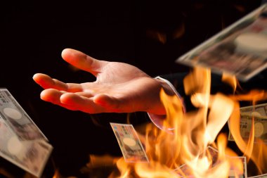 İnsan eli ateşe dolar atıyor.