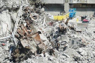 Yıkılmış bina enkazı bükülmüş metal ve beton enkazı gösteriyor.