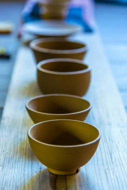 Boş seramik çay kaseleri ahşap bir tahtanın üzerinde.