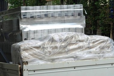 Açık havada plastik filme sıkıca sarılmış karton kutular.