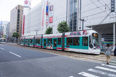 Ticari binalar, Japon demiryolu üst geçidinin büyük, beton tabanına yakındır..