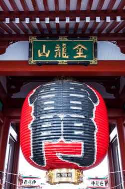 Geleneksel ahşap yapının altında asılı büyük kırmızı fener.