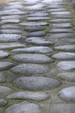 Smooth rounded cobblestones forming old stone pathway outdoors