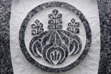 Parlak taş yüzeyine oyulmuş karmaşık çiçek amblemi.