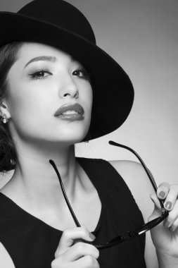 Siyah şapkalı güzel Asyalı bir kadının portresi. siyah beyaz fotoğraf. moda.