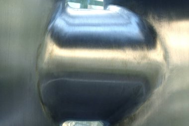 Kapalı, parlak metalik yüzey açık havada yumuşak doğal ışığı yansıtıyor.