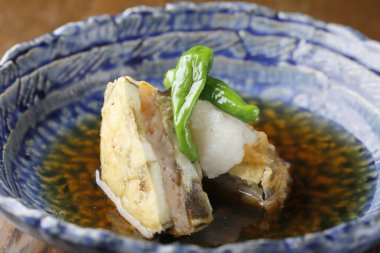 Crispy fried fish served in blue ceramic bowl with sauce