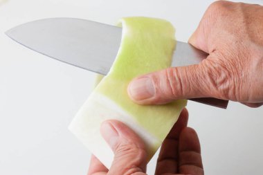 Kadın elleri bıçakla sebze soyuyordu. 