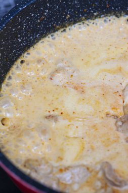 Soslu tavuk eti ve tavada baharat.