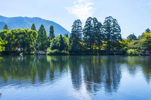 Yufuin, Oita, Kyushu, Japonya 'daki Yufu Dağı ve mavi gökyüzü geçmişi ile Kinrin Gölü.