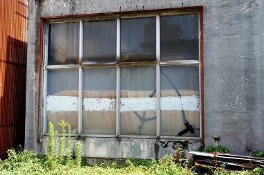 Eski endüstriyel bir evin kırık penceresi.