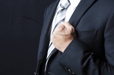 Koyu arkaplanda takım elbise giyen ve kravat takan işadamı görüntüsü