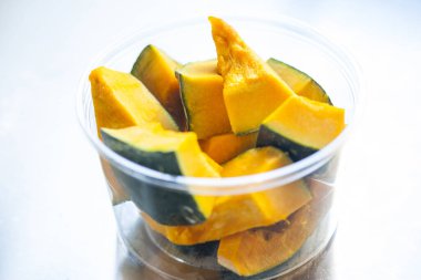 Plastik bir kapta dilimlenmiş balkabağı.