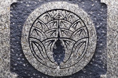 Karmaşık simetrik yaprak desenleri içeren oymalı taş amblemi