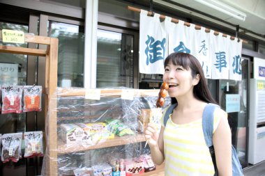 Japon sokak yemeklerini yiyen bir kadın.