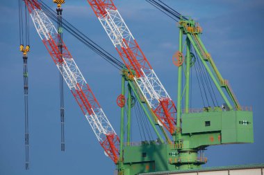 Mavi gökyüzü olan vinçler ve şantiyeler