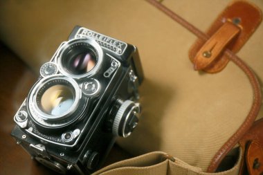 Kahverengi deri çantanın önünde eski çift lensli kamera Rolleiflex