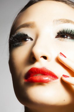 Stüdyoda şık makyajlı güzel Asyalı bir kadının yakın plan fotoğrafı.