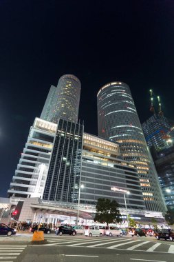 Aydınlatılmış gökdelenler Yoğun şehir sokağının üzerinde yükseliyor