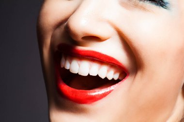 Kırmızı rujlu gülümseyen genç kızın portresi.