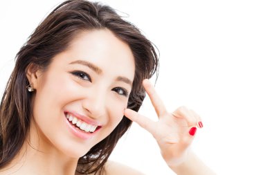 Genç Asyalı kadın barış işareti gösteriyor.