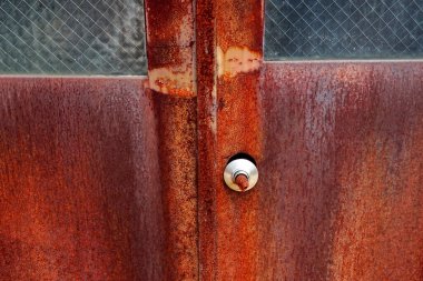 Rusty metal door handle with textured surface and glass
